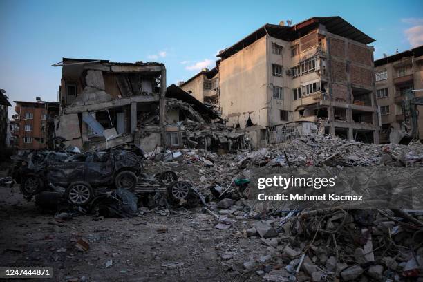 Wrecked cars are seen in front of the collapsed buildings on February 24, 2023 in Hatay, Turkey. A 7.8-magnitude earthquake hit near Gaziantep,...