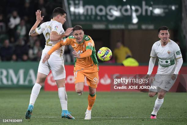 Elche's Argentinian defender Federico Fernandez fights for the ball with Real Betis' Spanish midfielder Joaquin during the Spanish League football...