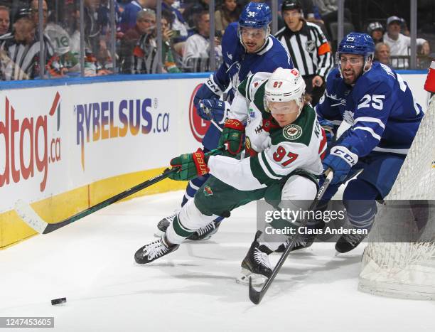 Kirill Kaprizov of the Minnesota Wild skates with the puck against Conor Timmins of the Toronto Maple Leafs during an NHL game at Scotiabank Arena on...