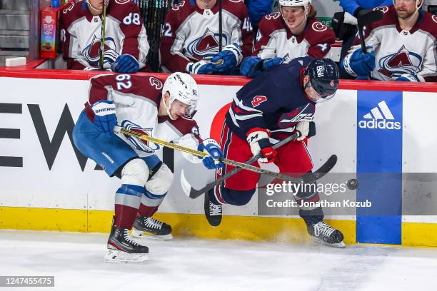 Neal Pionk of the Winnipeg Jets plays the puck away from Artturi Lehkonen of the Colorado Avalanche during first period action at the Canada Life...