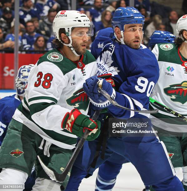 Ryan Hartman of the Minnesota Wild battles against Ryan O'Reilly of the Toronto Maple Leafs during an NHL game at Scotiabank Arena on February 24,...