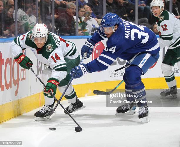 Joel Eriksson Ek of the Minnesota Wild battles for the puck against Auston Matthews of the Toronto Maple Leafs during an NHL game at Scotiabank Arena...