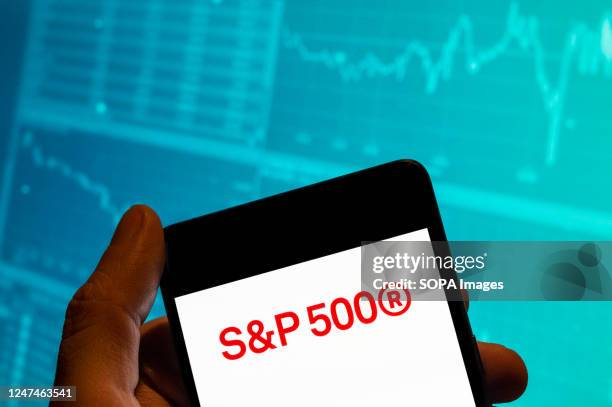 In this photo illustration, the US stock market index tracking the stock performance of 500 large companies listed S&P 500 logo is seen displayed on...