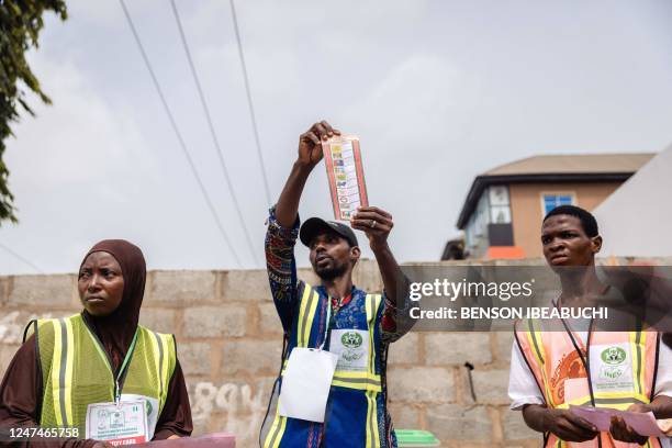 An Independent National Electoral Commission holds up a ballot paper during the counting process at a polling station in Egbeda, Lagos, on February...