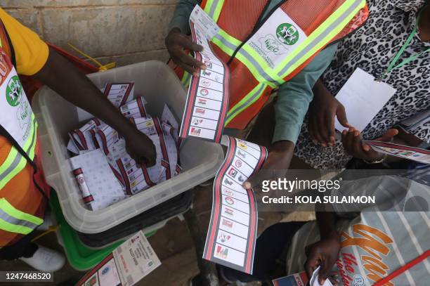 Independent National Electoral Commission officials sort and count ballots during the vote counting process at a polling station in Kano on February...