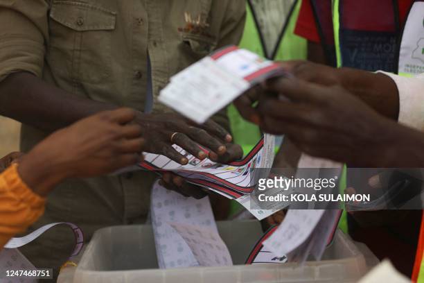 Independent National Electoral Commission officials sort and count ballots during the vote counting process at a polling station in Kano on February...