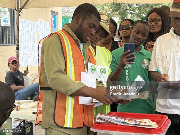 Polling clerks start to count the votes at a polling station after completing the voting process of the general election in Abuja, Nigeria on...