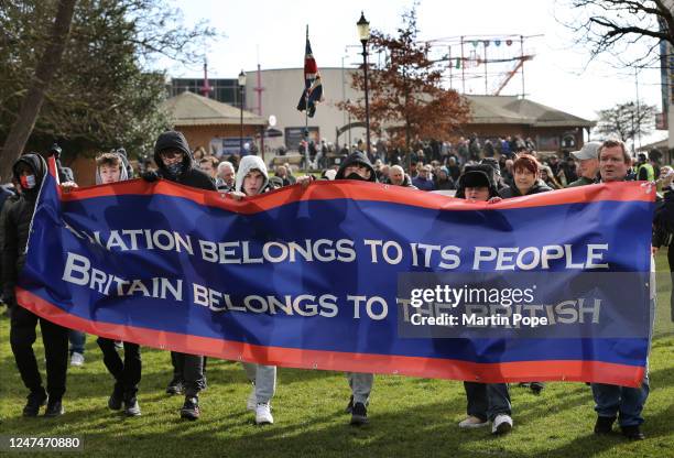 Protesters march behind a nationalist banner on February 25, 2023 in Skegness, England. Local residents of the town are protesting after five hotels,...