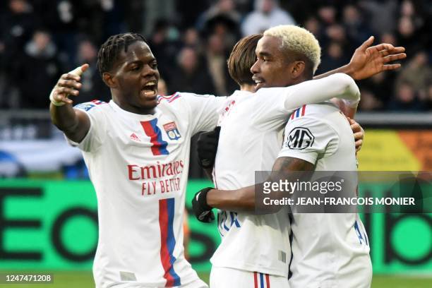 Lyon's Brazilian midfielder Thiago Mendes celebrates after scoring his team's first goal with Lyon's French midfielder Maxence Caqueret and Lyon's...