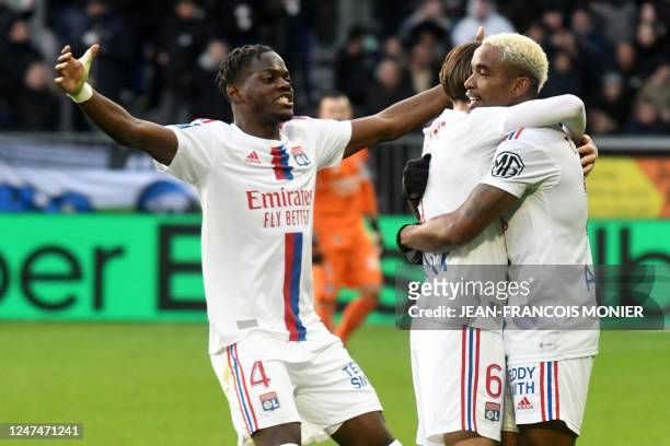 Lyon's Brazilian midfielder Thiago Mendes celebrates after scoring his team's first goal with Lyon's French midfielder Maxence Caqueret and Lyon's...