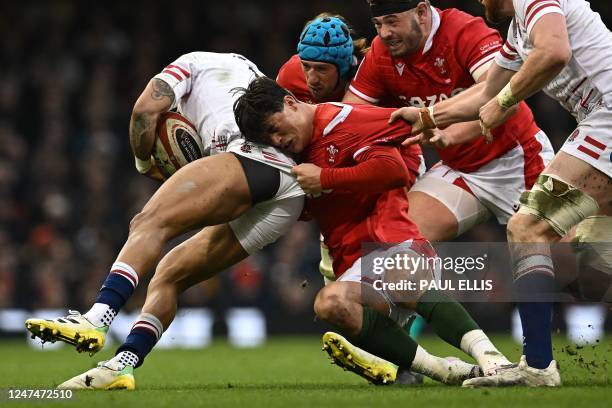 Wales' wing Louis Rees-Zammit pulls on the shorts of England's wing Anthony Watson during the Six Nations international rugby union match between...