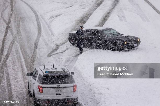 California Highway Patrol officer assists a stuck motorist on the State Route 14 freeway after it is shut down in both directions because of heavy...