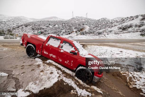 Truck is left stuck in a snowy ditch along Sierra Highway on February 25, 2023 near Acton, California. The National Weather Service issued a blizzard...