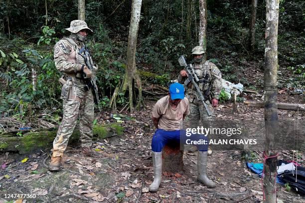 Officers of the Brazilian Institute of Environment and Renewable Natural Resources arrest an illegal miner during an operation against Amazon...