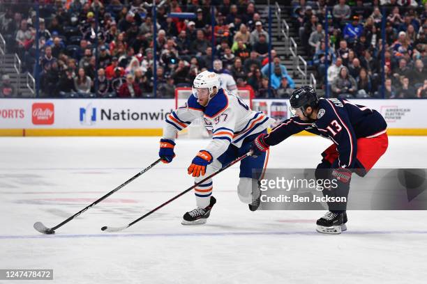 Connor McDavid of the Edmonton Oilers skates with the puck as Johnny Gaudreau of the Columbus Blue Jackets defends during the second period of a game...