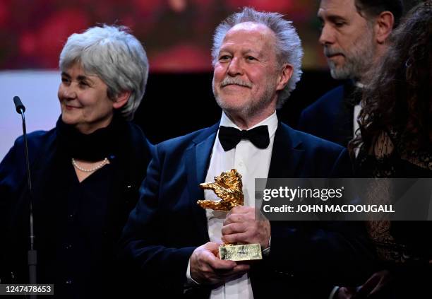 French director Nicolas Philibert stands next to producers Milena Poylo and Gilles Sacuto as he poses with poses with the "Golden Bear for Best Film"...