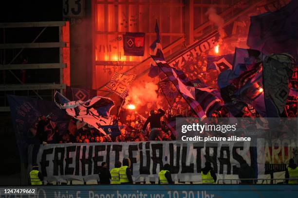 February 2023, Hesse, Darmstadt: Soccer: 2nd Bundesliga, Darmstadt 98 - Hamburger SV, Matchday 22, Merck-Stadion am Böllenfalltor. HSV fans set off...