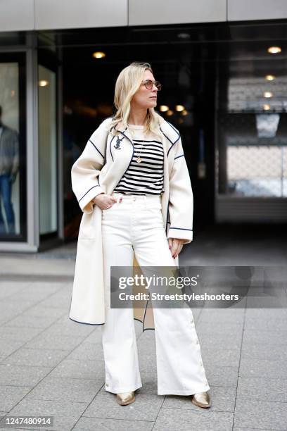 Tamara von Nayhauss wearing a Yves Saint Laurent vintage coat, white flare jeans with gold buttons by Maje, a striped sweater by Zara, a necklace by...