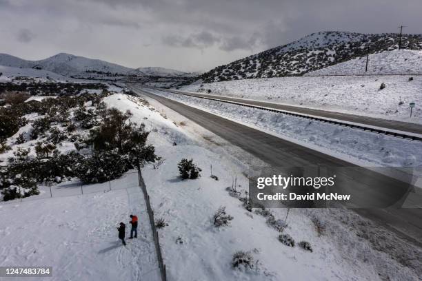 In an aerial view, people walk near to the State Route 14 freeway that was shut down in both directions during a snowstorm on February 25, 2023 near...