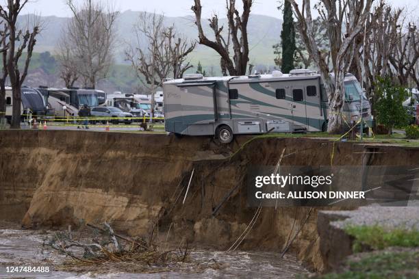 An RV begins to fall into the Santa Clara River as the ground bellow it is washed away by flooding due to heavy rain washing away over 150 feet of...