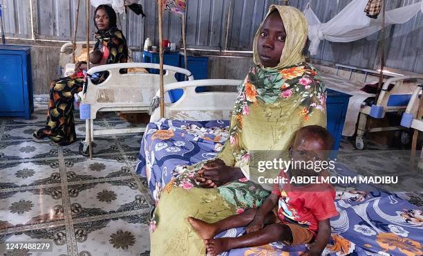 Women and a children sit waiting at a nutrition centre at the Kalma camp for the displaced just outside Nyala, the provincial capital of South Darfur...