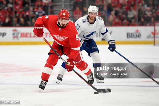 Jake Walman of the Detroit Red Wings skates with the puck as he is chased by Brayden Point of the Tampa Bay Lightning in the first period of an NHL...