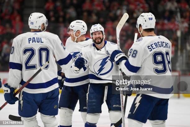 Nikita Kucherov of the Tampa Bay Lightning scores a goal and is congratulated by Nicholas Paul and Mikhail Sergachev in the second period of an NHL...