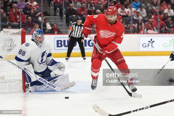 Joe Veleno of the Detroit Red Wings and Andrei Vasilevskiy of the Tampa Bay Lightning both look at the puck in the third period of an NHL game at...