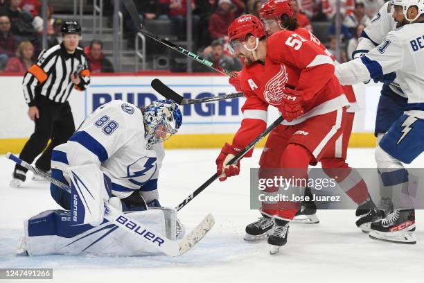 Andrei Vasilevskiy of the Tampa Bay Lightning makes a save as David Perron of the Detroit Red Wings tries to knock the puck out of his glove in the...