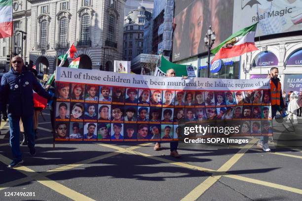 Protesters in Piccadilly Circus hold a banner showing children who they say have been killed by the regime in Iran, during the demonstration. Various...