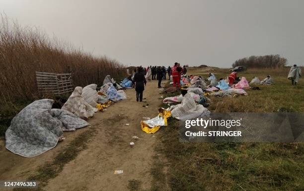 This photo obtained from Italian news agency Ansa, taken on February 26, 2023 shows rescued migrants wrapped in a blanket in Steccato di Cutro, south...