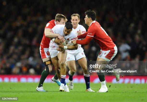 Englands's Anthony Watson is tackled by Wales Nick Tompkins and Louis Rees-Zammit during the Six Nations Rugby match between Wales and England at...