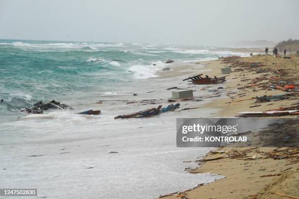 The remains of the boat destroyed by the waves of the stormy sea and at the bottom a corpse of a migrant inside a white bag, while men from the...