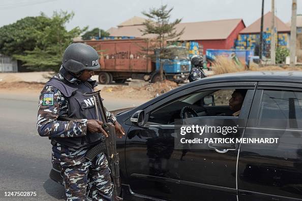 Nigerian Police Officer Stops A Car At A Security Checkpoint In Awka nigerian-police-officer-stops-a-car-at-a-security-checkpoint-in-awka