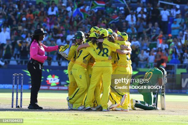 South Africa's Sinalo Jafta reacts as Australian players celebrate winning the final T20 women's World Cup cricket match between South Africa and...