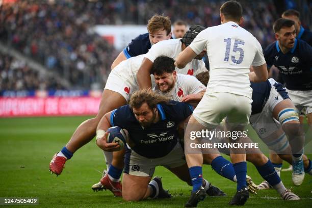 Scotland's prop Pierre Schoeman is tacled by France's hooker Julien Marchand during the Six Nations rugby union tournament match between France and...
