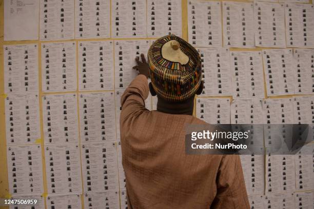 Voter check for his names on the voters roll pasted on a wall during the Nigeria Presidential election at a polling station at the Federal Capital...