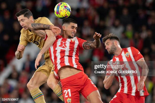 Barcelona's Polish forward Robert Lewandowski and Almeria's Spanish defender Chumi jump for the ball during the Spanish League football match between...