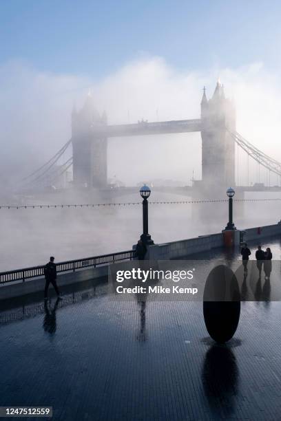 Thick fog starts to clear over the capital at Tower Bridge and the riverside walkway making a peaceful yet eerie atmosphere as structures appear and...