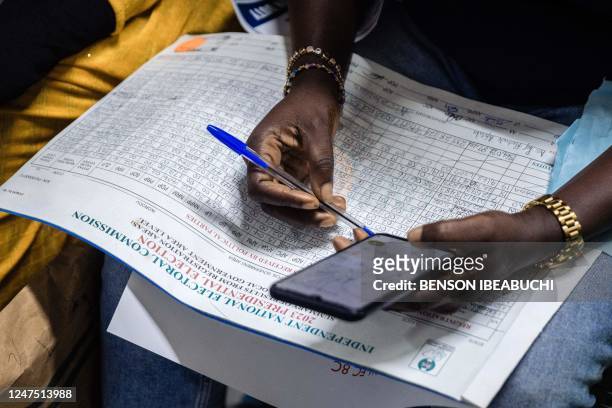 Presiding officer counts records from the Ikorodu local government area during the collation of the presidential election results at the Independent...
