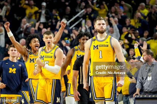 Kobe Bufkin and Joey Baker of the Michigan Wolverines react after Hunter Dickinson of the Michigan Wolverines made a shot that forced the game into...