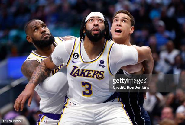Anthony Davis and teammate LeBron James of the Los Angeles Lakers box out Dwight Powell of the Dallas Mavericks for a rebound in the first half of...