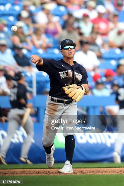 New York Yankees infielder Anthony Volpe throws the ball over to first base during the spring training game between the New York Yankees and the...