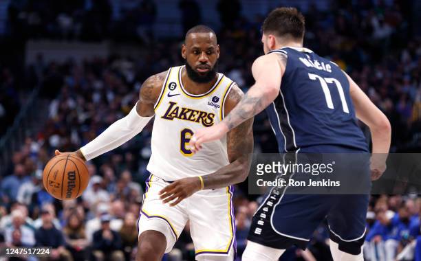 LeBron James of the Los Angeles Lakers handles the ball as Luka Doncic of the Dallas Mavericks defends in the second half at American Airlines Center...