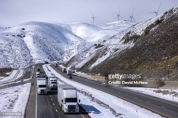 Truckers drive State Route 58 across the southern Sierra Nevada Mountains following its reopening in the wake of a powerful storm that brought snow...