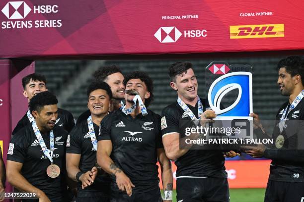 New Zealand's All Blacks Sevens team celebrates with their trophy after winning the cup final against Argentina on the second day of the Los Angeles...