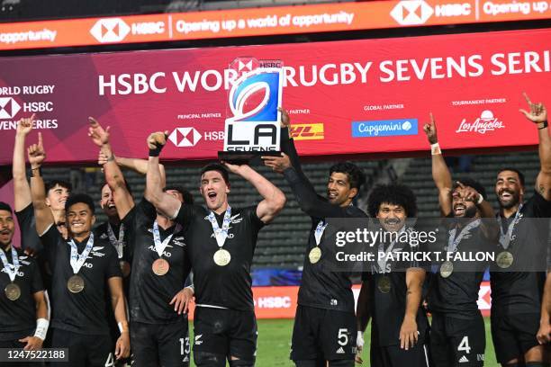 New Zealand's All Blacks Sevens team celebrates with their trophy after winning the cup final against Argentina on the second day of the Los Angeles...