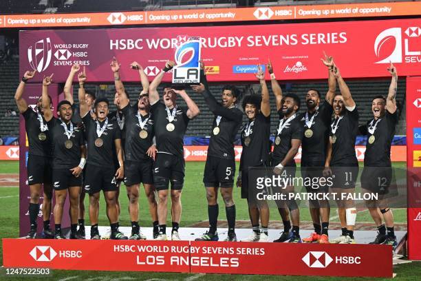 New Zealand's All Blacks Sevens team celebrates with their trophy after winning the cup final against Argentina on the second day of the Los Angeles...