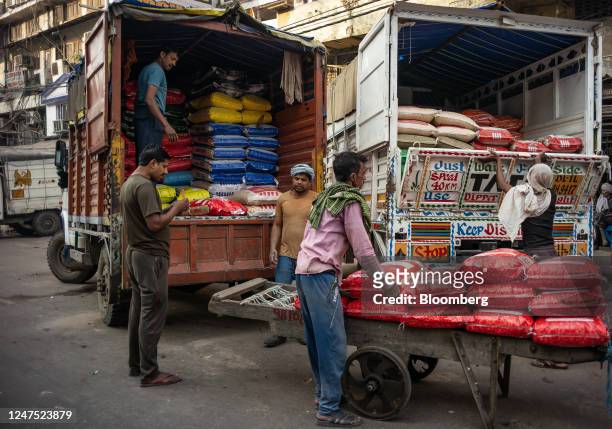 Workers load sacks of flour onto trucks at a market in New Delhi, India, on Sunday, Feb. 26, 2023. Indias GDP growth likely slowed to 4.6% year on...