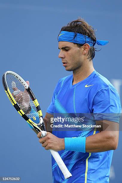 Rafael Nadal of Spain inspects his racquet against Novak Djokovic of Serbia during the Men's Final on Day Fifteen of the 2011 US Open at the USTA...